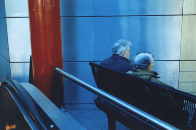 360070 Afbeelding van twee personen op een bankje in de Stationshal te Utrecht.